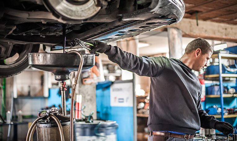 Mechanic changing car's oil